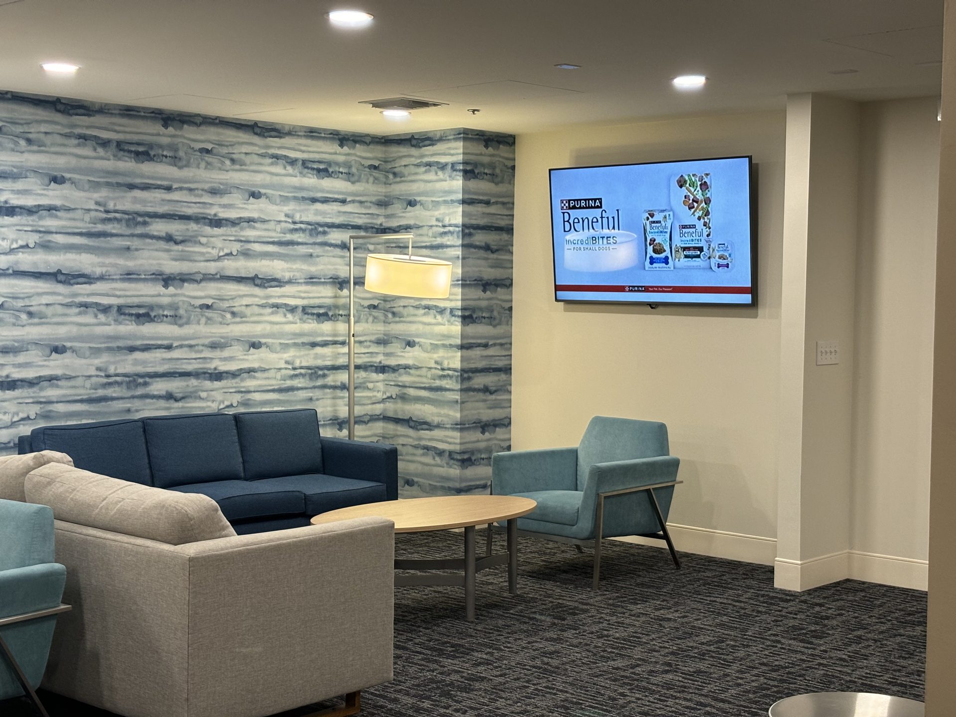 Finished commercial lobby lounge in Orlando with a wall-mounted large-format display and Lutron-controlled lighting